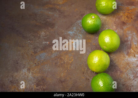 Freshly lime fruits on trendy rust background Stock Photo