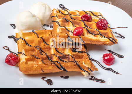 Viennese waffles with ice cream, chocolate and cherry. Close-up. On the plate Stock Photo