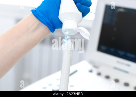 gynecologist doctor prepares an ultrasound machine for the diagnosis of the patient. Applies gel to a transvaginal ultrasound scanner. Women's Health Stock Photo