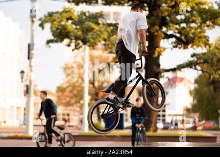 The guy performs a stunt on BMX, jumping up. Stock Photo