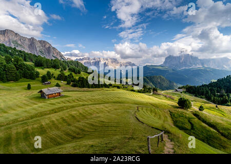 The green grass fields and a hut at the beautiful Val Gardena valley in Dolomites mountains, Alps, Italy. Stock Photo