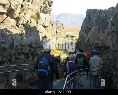 Tourists follow through the trail through the Almannagja Gorge in Thingvellir National Park, where the North American & Eurasian tectonic plates split. Stock Photo