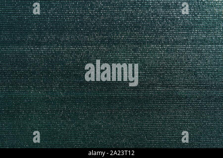 Dark green knitted polyethylene mesh background. Agro sun shade net textured surface sample. Greenhouse equipment. Artificial material backdrop. Stock Photo