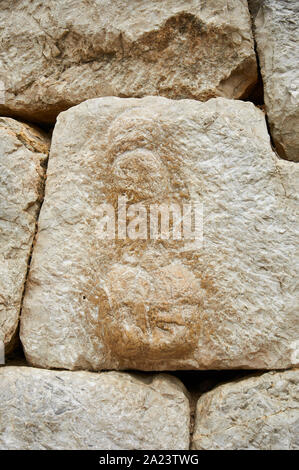 Phallic symbol in carved stone masonry in the roman city wall at Empúries Archaeological Site (Ampurias, La Escala, Alt Empordà, Girona, Spain) Stock Photo