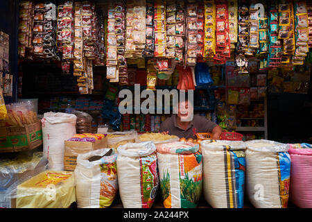 A Chinese dry goods, rice merchant in the old, local, traditional market, Pasar Pabean. In the Arab Quarter section of Surabaya, Indonesia. Stock Photo