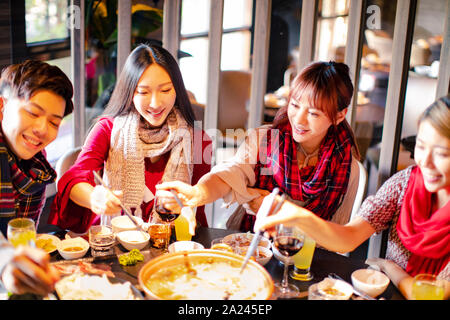 Happy friends having fun in hot pot restaurant Stock Photo