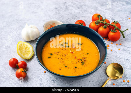 Close up of a blue plate with red lentil soup with vegetables Stock Photo