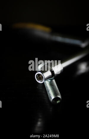 Ring wrench and bolt on a black background Stock Photo