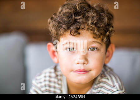Handsome young boy with curly hair smiling. Stock Photo
