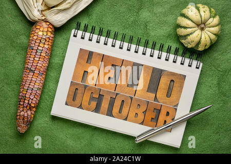 Hello October - letterpress wood type blocks typography in a spiral notebook with decorative corn and gourd, greeting card concept Stock Photo