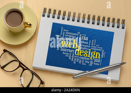 web design and development word cloud with binary background in a spiral sketchbook, flat lay with a cup of coffee Stock Photo