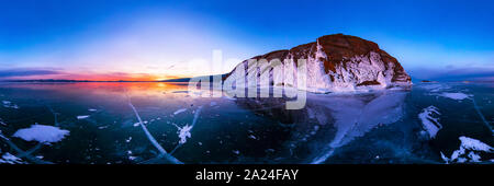 colorful sunset on winter lake Baikal near an island covered with ice. . Cylindrical panorama 360. Stock Photo