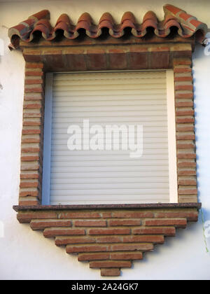 Brick suround arabic style window with closed white blinds Stock Photo