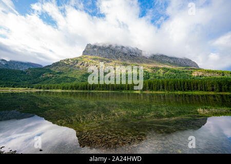 Morning view of the Fishercap Lake with reflection at Glacier National Park Stock Photo