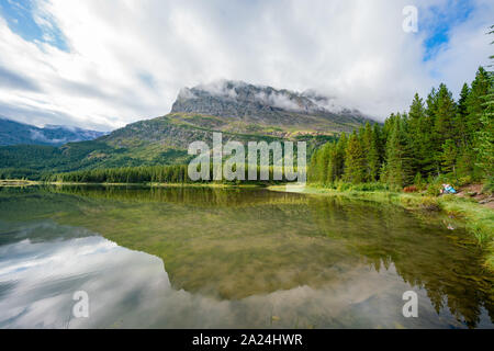 Morning view of the Fishercap Lake with reflection at Glacier National Park Stock Photo