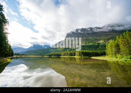 Morning view of the Fishercap Lake with reflection at Glacier National Park Stock Photo