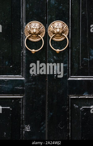 Lion chinese door knockers on a black door in China Stock Photo