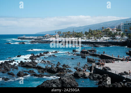 Tenerife, Spain - August, 2019: People swimming in ocean pools at coast of   Puerto de la Cruz, Tenerife Stock Photo