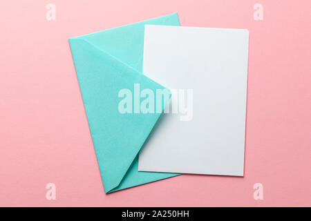 Green envelope and blank letter on pink background. Template with place for text on postcard. mock-up. Stock Photo