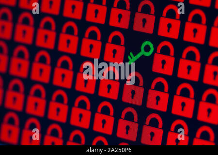 Key as a symbol of access or hacking of open personal information. Red pixel locks and a green key on a black background, close-up. Stock Photo