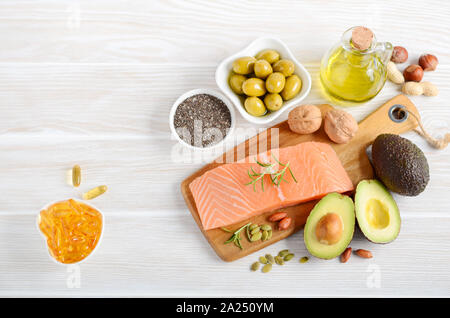 Selection of healthy unsaturated fats, omega 3 - fish, avocado, olives, nuts and seeds. Stock Photo