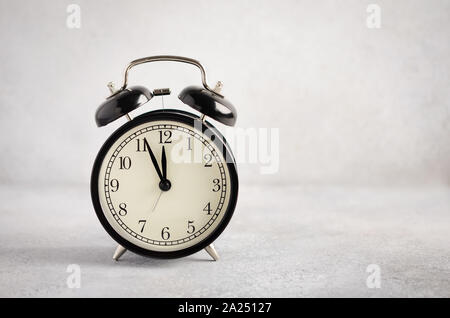 New Year and Christmas concept. Black alarm clock on a gray concrete background. Stock Photo