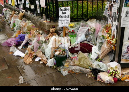 Floral tributes marking the  Grenfell Tower fire in London. The fire occurred on 14 June 2017. at the 24-storey Grenfell Tower block of public housing flats in North Kensington, West London. It caused at least 80 deaths and over 70 injuries. The rapid growth of the fire is thought to have been accelerated by the building's exterior cladding, which is of a common type in widespread use. Stock Photo
