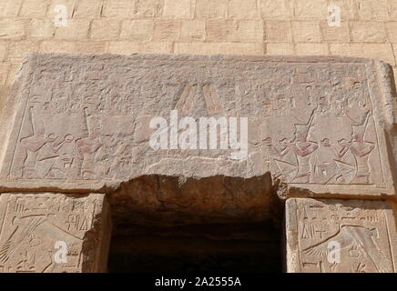 Doorway with painted relief, depicting two pharaohs; one on the left is wearing the hedjet or White Crown for Upper Egypt. The one on the right wears the deshret or Red Crown for Lower Egypt. Temple of Hatshepsut, near Luxor, Egypt. The mortuary temple and tomb dates to the Eighteenth dynasty, and was designed by Senenmut, royal steward and architect of Hatshepsut. It was constructed during the 15th century BC, During the Eighteenth dynasty Stock Photo