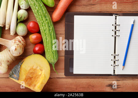 Thai kitchen. Various vegetables, spices  and Ingredients with blank notebook and pencil on wooden background. Top view Stock Photo