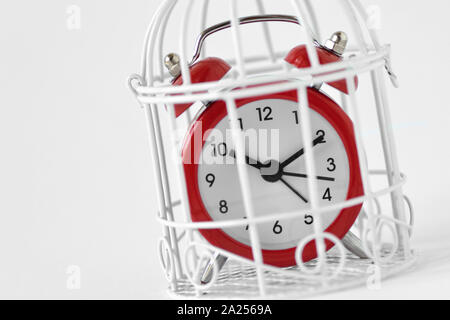 Close-up of red alarm clock in a cage - Concept of time limit Stock Photo