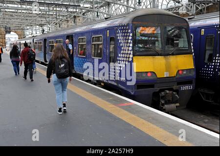 Passengers boarding Scotrail Class 320 electric trains at Glasgow Central Station Stock Photo