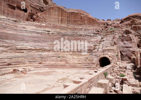 first century AD Nabatean theatre in Petra, Jordan. Substantial part of the theatre was carved out of solid rock, while the scaena and exterior wall were constructed. The theatre's auditorium consists of three horizontal sections of seats separated by passageways and seven stairways to ascend. The theatre could accommodate a number of approximately 8500 people. The theatre was built in the cultural and political apex of the Nabatean kingdom under Aretas IV (9 BC-40 AD), In 1812, the city of Petra and Al-Khazneh was rediscovered by Swiss explorer Johann Ludwig Burckhardt Stock Photo