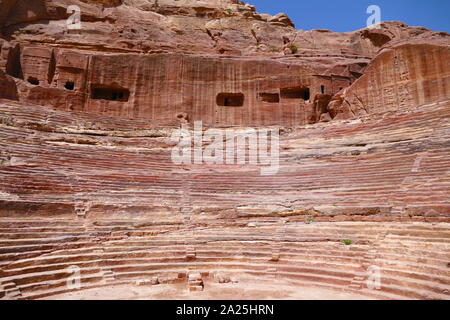 first century AD Nabatean theatre in Petra, Jordan. Substantial part of the theatre was carved out of solid rock, while the scaena and exterior wall were constructed. The theatre's auditorium consists of three horizontal sections of seats separated by passageways and seven stairways to ascend. The theatre could accommodate a number of approximately 8500 people. The theatre was built in the cultural and political apex of the Nabatean kingdom under Aretas IV (9 BC-40 AD), In 1812, the city of Petra and Al-Khazneh was rediscovered by Swiss explorer Johann Ludwig Burckhardt Stock Photo