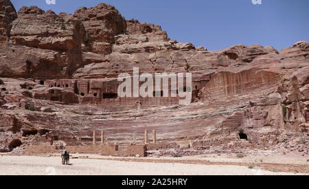 first century AD Nabatean theatre in Petra, Jordan. Substantial part of the theatre was carved out of solid rock, while the scaena and exterior wall were constructed. The theatre's auditorium consists of three horizontal sections of seats separated by passageways and seven stairways to ascend. The theatre could accommodate a number of approximately 8500 people. The theatre was built in the cultural and political apex of the Nabatean kingdom under Aretas IV (9 BC-40 AD), In 1812, the city of Petra and Al-Khazneh was rediscovered by Swiss explorer Johann Ludwig Burckhardt Stock Photo