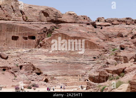 first century AD Nabatean theatre in Petra, Jordan. Substantial part of the theatre was carved out of solid rock, while the scaena and exterior wall were constructed. The theatre's auditorium consists of three horizontal sections of seats separated by passageways and seven stairways to ascend. The theatre could accommodate a number of approximately 8500 people. The theatre was built in the cultural and political apex of the Nabatean kingdom under Aretas IV (9 BC-40 AD), In 1812, the city of Petra and Al-Khazneh was rediscovered by Swiss explorer Johann Ludwig Burckhardt Stock Photo