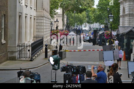 Arrival at downing street, of the outgoing, british prime minister, theresa may after her resignation. press gathered in downing street, london, the official residences and offices of the prime minister of the united kingdom and the chancellor of the exchequer. situated off whitehall, a few minutes' walk from the houses of parliament, downing street was built in the 1680s by sir george downing. Stock Photo