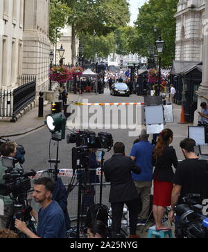 Arrival at downing street, of the outgoing, british prime minister, theresa may after her resignation. press gathered in downing street, london, the official residences and offices of the prime minister of the united kingdom and the chancellor of the exchequer. situated off whitehall, a few minutes' walk from the houses of parliament, downing street was built in the 1680s by sir george downing. Stock Photo