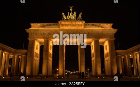 The Brandenburg Gate (Brandenburger Tor) viewed at night. An 18th-century neoclassical monument in Berlin, built on the orders of Prussian king Frederick William II after the restoration of order during the early Batavian Revolution. One of the best-known landmarks of Germany, the Quadriga, is a sculpture of a chariot drawn by four horses, sculpted by Johann Gottfried Schadow Stock Photo