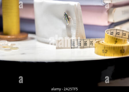 Tailor's Table with Thread and Tape Measure and Shirt Cloth Swatches Stock Photo