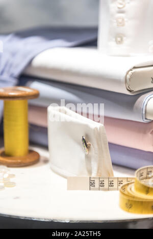 Tailor's Table with Thread and Tape Measure and Shirt Cloth Swatches Stock Photo