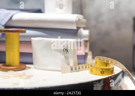 Tailor's Table with Thread and Tape Measure and Shirt Cloth Swatches Stock Photo