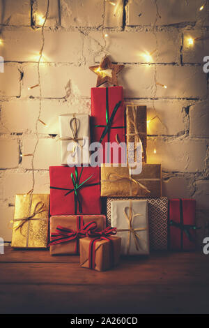 stack of christmas gifts on white brick wall background Stock Photo