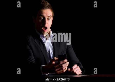 Businessman surprised about text messages on phone. Stock Photo