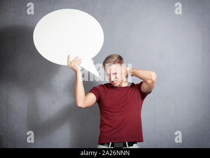 Disappointed man holding white blank speech balloon. Stock Photo