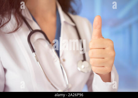 Young handsome doctor woman wearing stethoscope over hospital background approving doing positive gesture with hand, thumbs up smiling and happy for s Stock Photo