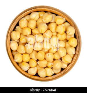 Cooked chickpeas in wooden bowl. Light tan Kabuli chickpea variety. Chick peas, Cicer arietinum, high protein legume and ingredient of hummus. Stock Photo
