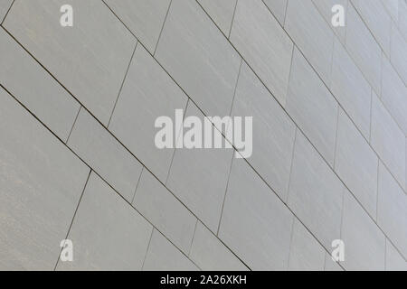 Low angle view of wall with gray smooth tiles of different shape (rectangular and square). Stock Photo