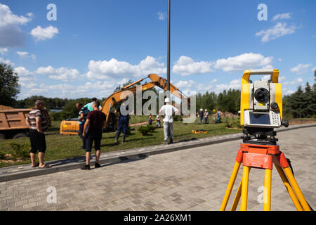 Front view of yellow and orange tacheometer standing on street Stock Photo