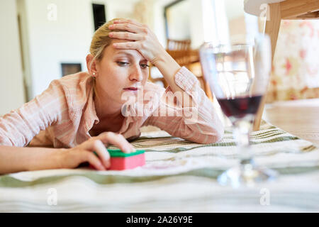 Exhausted housewife in red wine removing stain on carpet in living room Stock Photo