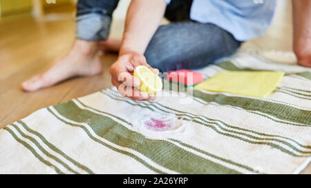 Housewife uses lemon and salt to remove red wine stain on carpet Stock Photo